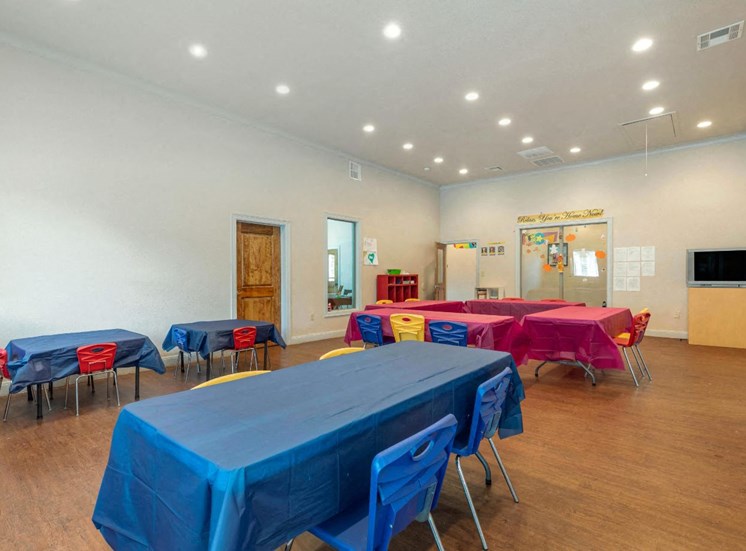 Resident activity room with tables and chairs